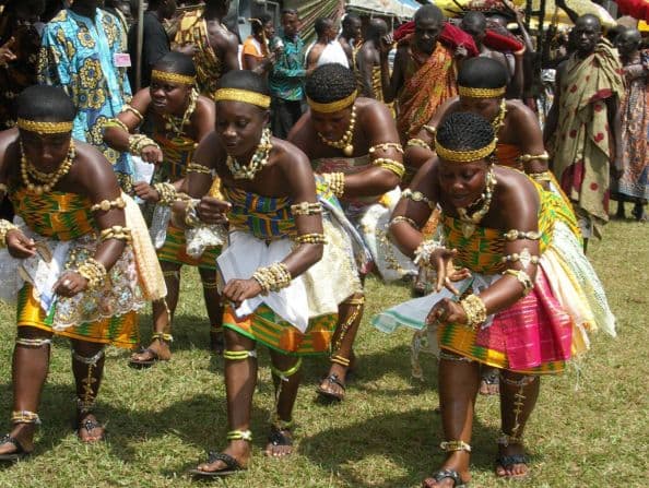 Traditional Akan dancers in kente at a public heritage event